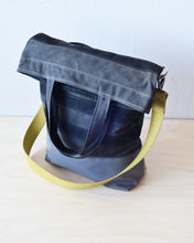 Load image into Gallery viewer, The top folds down to create a flap that conceals a generous zippered pocket.