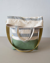 Load image into Gallery viewer, The top folds down to create a flap that conceals a generous zippered pocket. (showing the silver handle version).