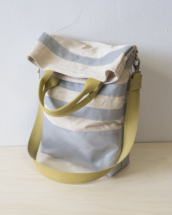 The top folds down to create a flap that conceals a generous zippered pocket. (showing the yellow strap handle version).